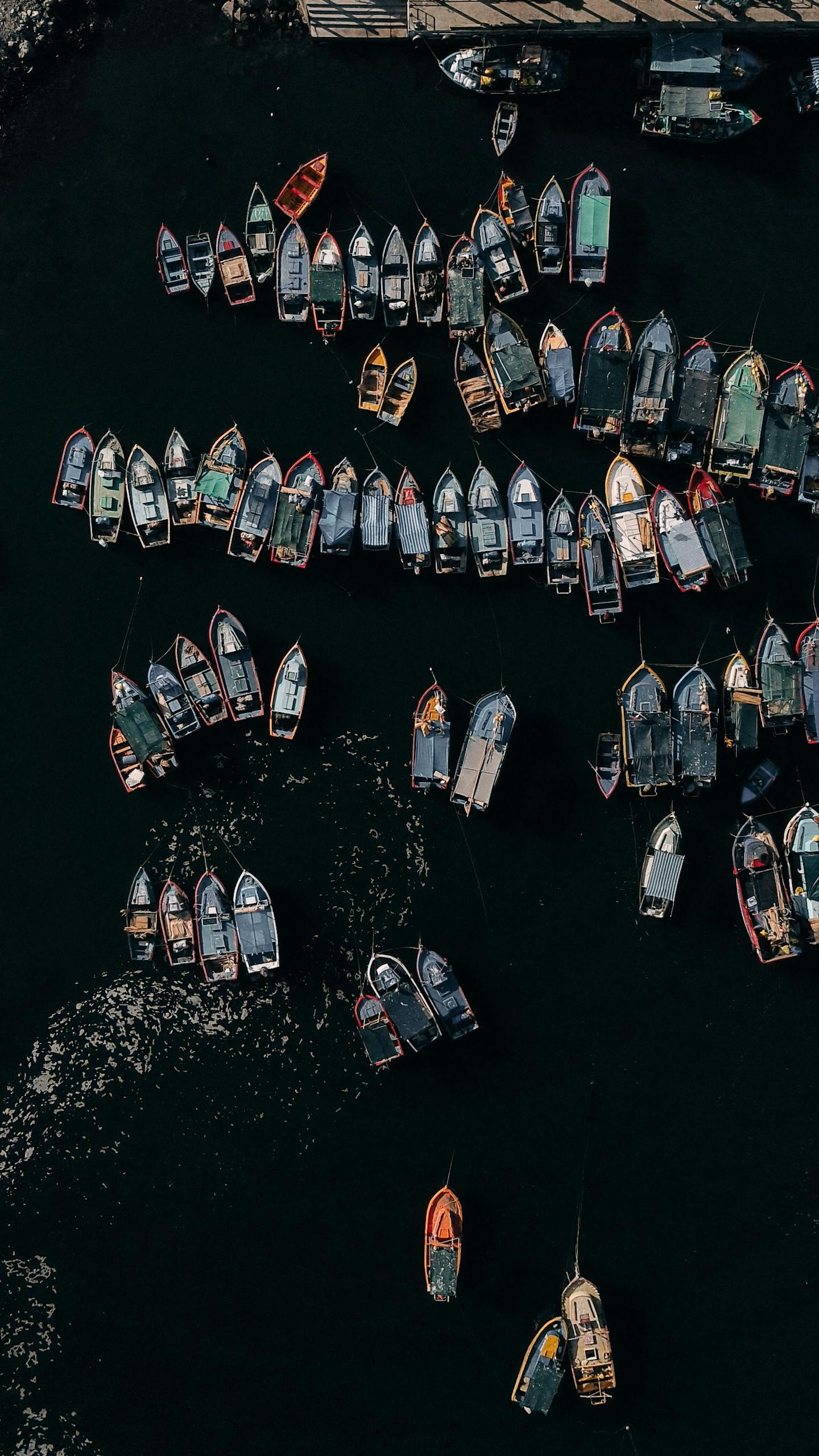 Stunning aerial shot of numerous boats docked at a busy harbor, showcasing maritime activity.